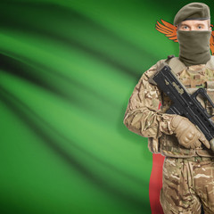 Fototapeta premium Soldier with machine gun and flag on background - Zambia