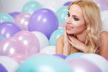 Fototapeta na wymiar Happy young woman with colorful latex balloons