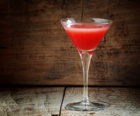 Red margarita cocktail in glass on old wooden background, dark t