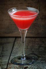 Red margarita cocktail in glass on old wooden background, dark t