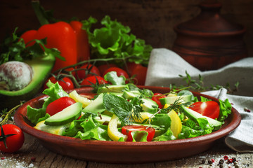Salad with avocado, cherry tomatoes, peppers, cucumbers, herbs,