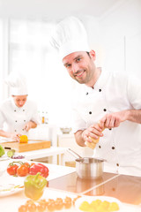 Young attractive professional chef cooking in his kitchen