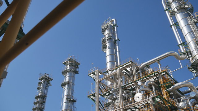 Refinery tower and steel pipe line in process area of Industrial refinery plant with blue sky 