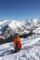 girl snowboarder standing on her knees on the slope