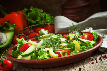 Salad with avocado, cherry tomatoes, peppers, cucumbers, herbs,