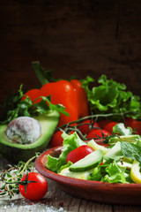 Salad with avocado, cherry tomatoes, peppers, cucumbers, herbs,