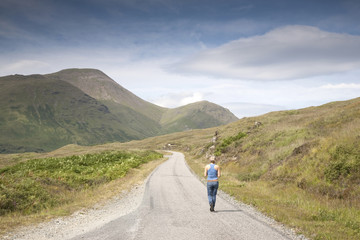 Fototapeta premium Woman on Empty Road; Isle of Mull; Scotland; UK