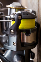 closeup fishing reel on wooden board background