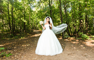 Young bride in wedding dress holding bouquet