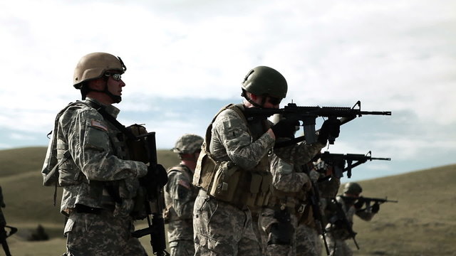 Several soldiers practicing firing assault rifles