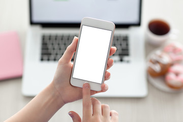 female hands holding phone with isolated screen and laptop