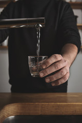 Barista fills small glass with water
