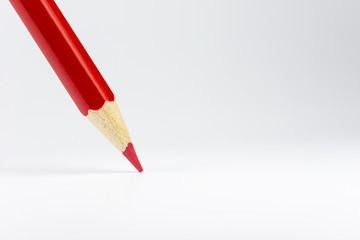 Standing red colored pencil on a white background.