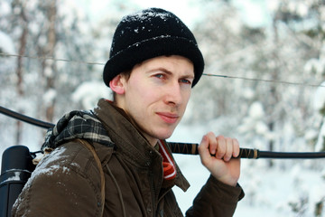 Охотник лучник с луком, стрелами и колчаном в зимнем снежном лесу на охоте