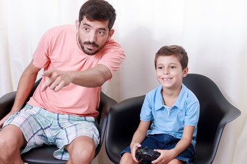 Obraz premium Father and son playing video game in the living room