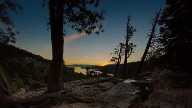 Timelapse tilting shot of the sunrise over a Emerald Bay in Nevada with lens flare