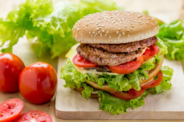 Delicious hamburger and french fries on wooden table