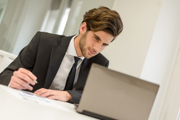 Businessman sitting at his laptop and working in the office
