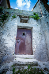 Rusty Medieval Door of an Old House. Fish Eye Lens. Blue Filter Applied. Vignette Applied. Shallow deep of Field.