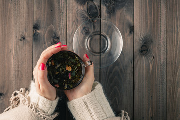 woman holding hot cup of black tea