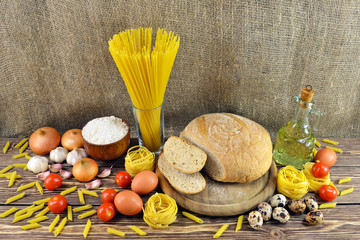Still-life photo bread with pasta and vegetables with ingredients on a table for dinner