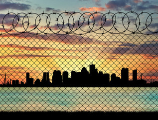 Silhouette of the city behind a fence