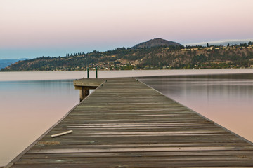 Fototapeta premium boat dock on still lake at sunrise in mountains