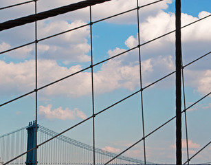 Il ponte di Manhattan visto attraverso i cavi del ponte di Brooklyn, New York