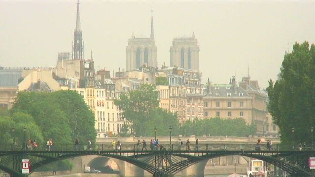 Royalty Free Stock Footage of Pedestrian bridge over the Seine with Paris skyline in the background.
