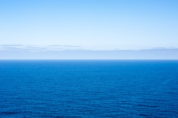 Fototapeta premium Deep blue empty ocean seascape with clouds on horizon