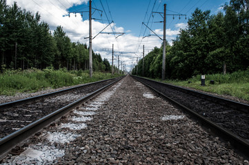 Naklejka premium Railway receding into the distance. Along the railway poles - electric transmission line. 