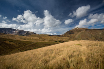 Autumn blue sky with white clouds and mountains on the yellowed