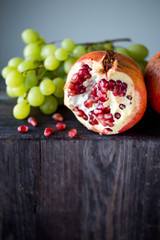 Still life of autumn fruits, pomegranates, grapes. Rustic.