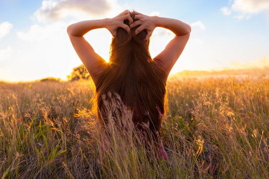Young woman enjoy sunshine in wheat field
