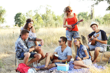 Young hippie people relaxing in the forest outdoors