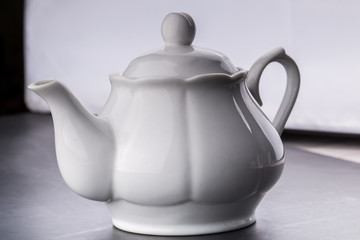 teapot and tea cup over dark background