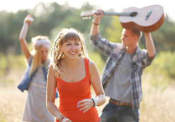 Obraz premium Carefree friends with guitars have fun, outdoors