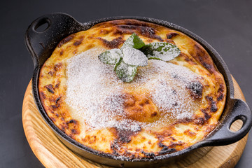 cottage cheese casserole on pan with powdered sugar
