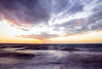 Fototapeta na wymiar purple sunset over rough sea