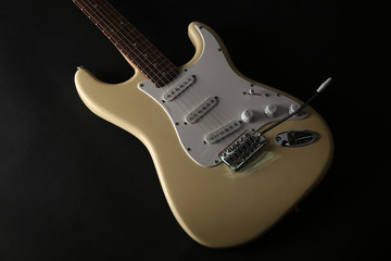 Part of white electric guitar, on black background