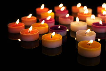 Many burning small candles on dark background