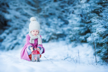Fototapeta na wymiar Adorable little girl with flashlight in frozen winter on Christmas outdoors