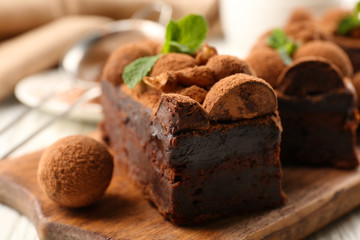 A piece of chocolate cake with walnut and mint on the table, close-up