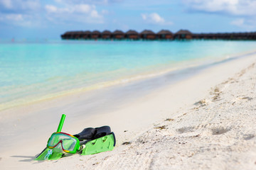 Mask, snorkel and fins for snorkeling on white sandy beach