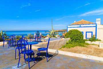 Restaurant tables with chairs on terrace near Praia da Rocha beach on coast of Portugal