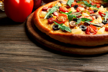 Delicious pizza with vegetables on wooden table
