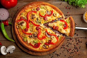 Delicious pizza with vegetables and slice on shovel, close-up