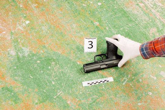 criminalist preventing gun at the murder scene