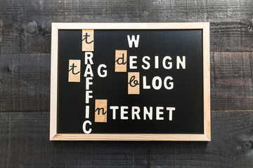 Wooden letters on slate and wood background with a concept message about internet and design concept and gearwheels