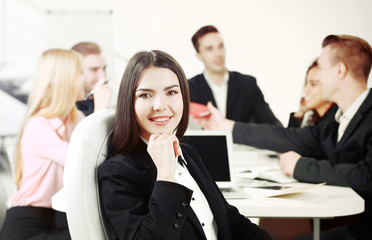 Photo of business woman with her staff in conference room at the meeting